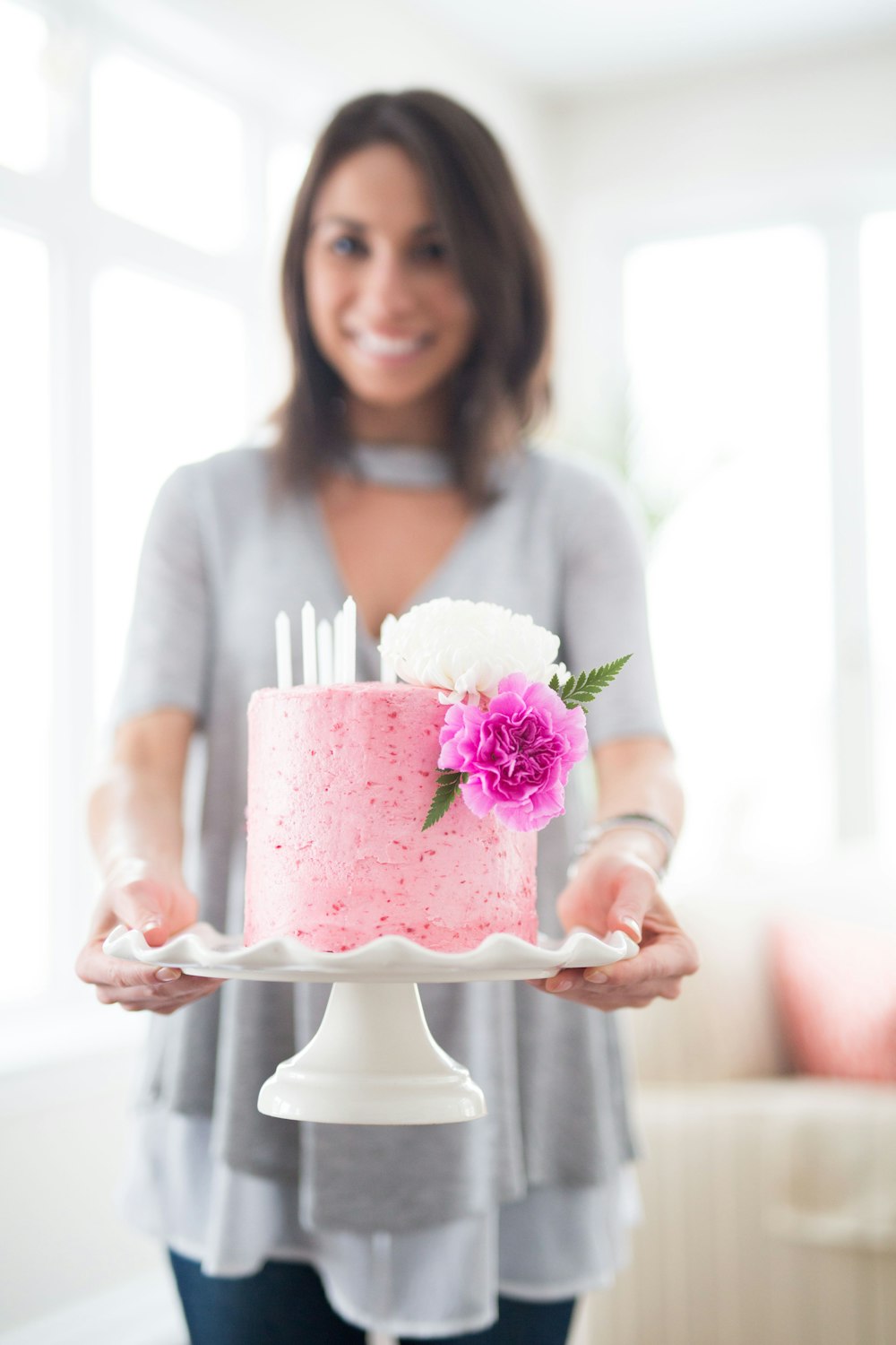 The baker holding a pink cake